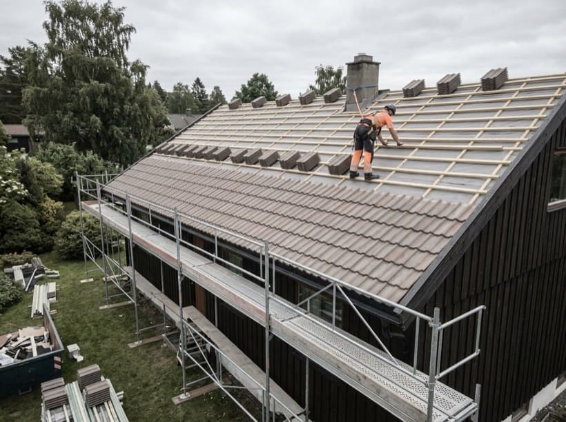 Illustrasjon av et tak under omlegging, med stillas rundt huset